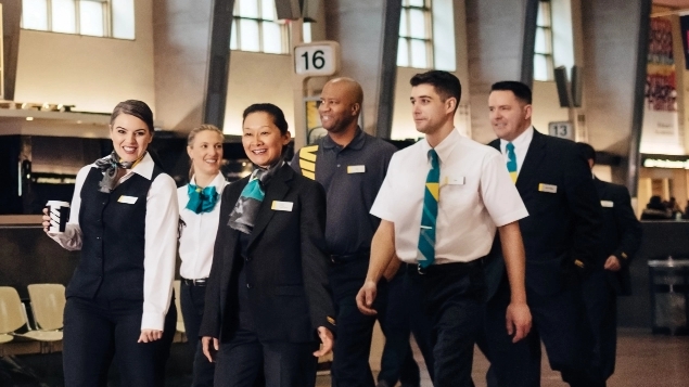 Diverse group of employees in uniform walking in a train station